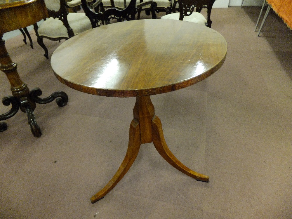 An early 20th century small round table having chamfered column resting on three splayed feet,