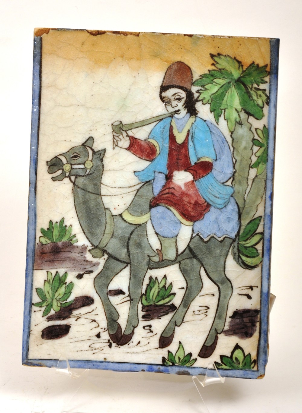 Persian tile of rectangular form decorated with a camel and rider, 29 x 21cm