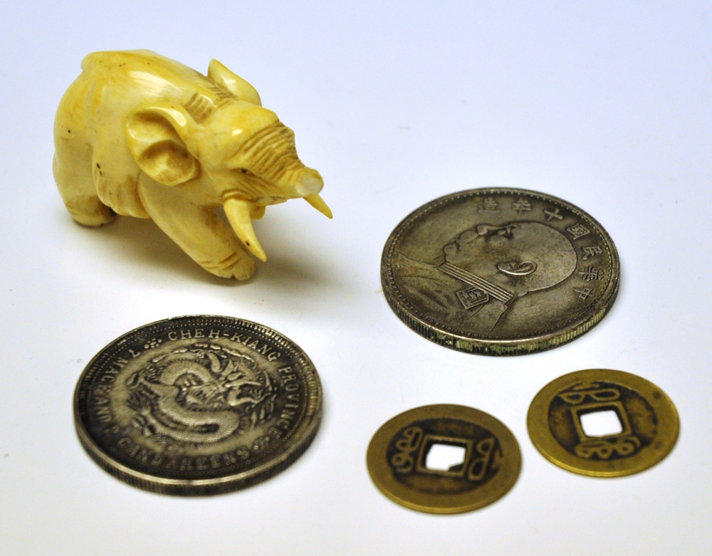 Four Chinese coins and a small ivory elephant (5)