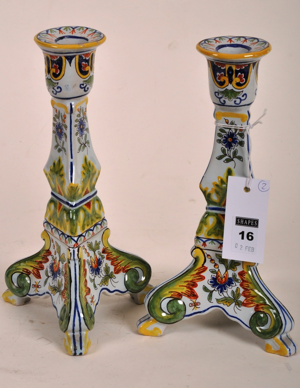 A pair of Cantigalli style tin glazed faience candlesticks, typically decorated, on triple