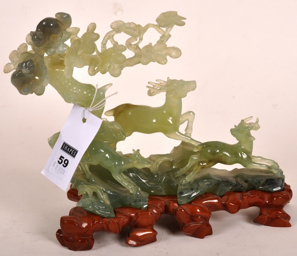 Chinese carved jade figure group depicting running deer in the woodland on a shaped wooden base,