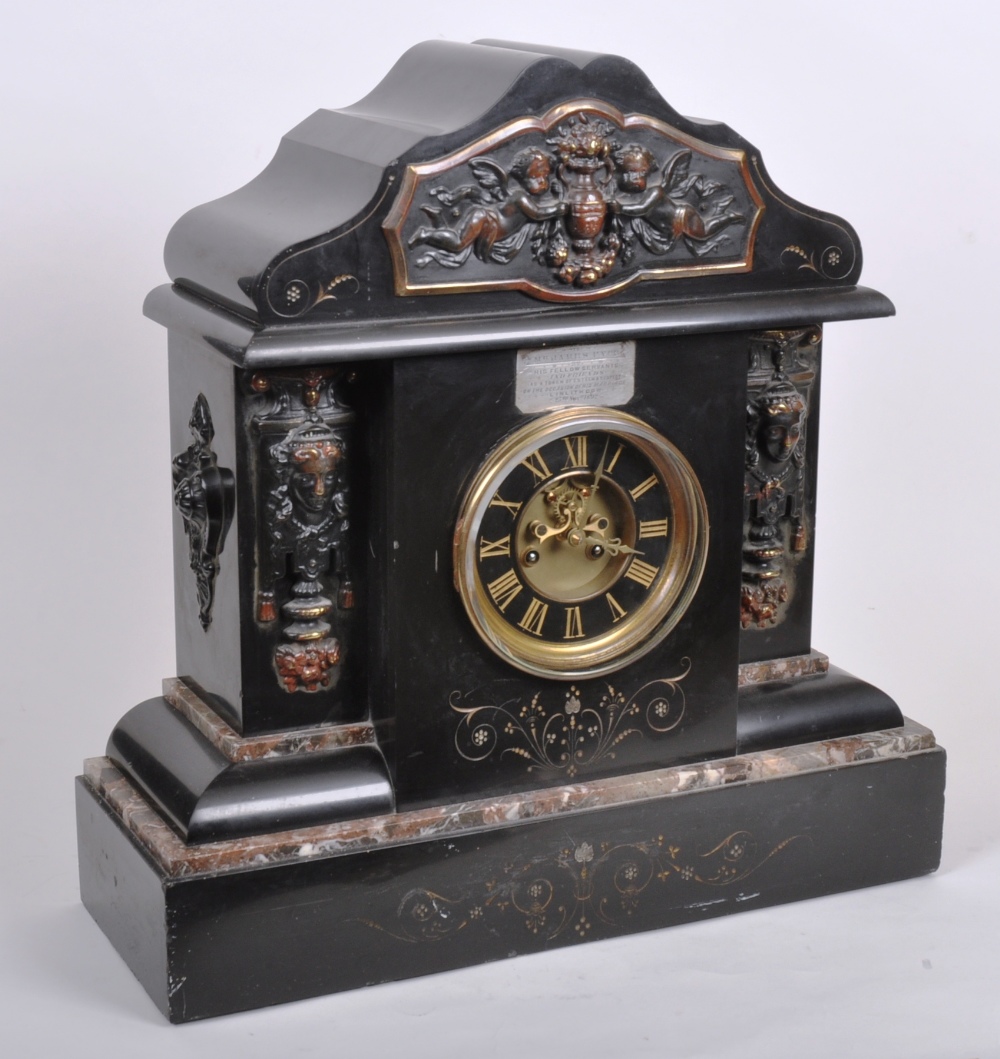 A large Victorian marble and slate mantle clock, the serpentine pediment over frieze panel depicting