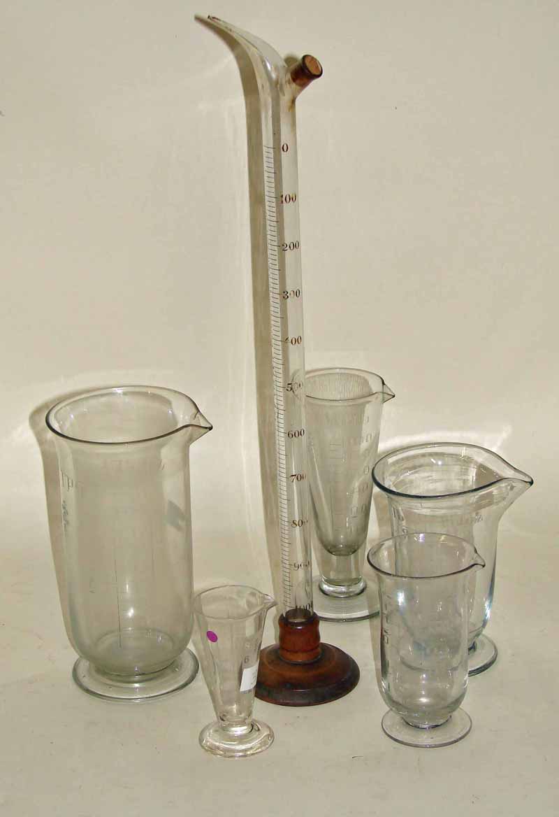 Thirteen Victorian and later conical measuring glasses, all but one with formed feet, three with