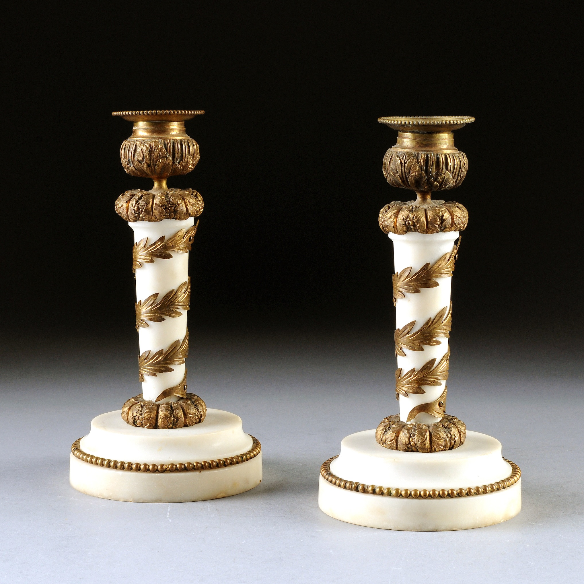 A PAIR OF EMPIRE STYLE MARBLE AND GILT BRONZE CANDLESTICKS, FRENCH, EARLY 19TH CENTURY, the tapering