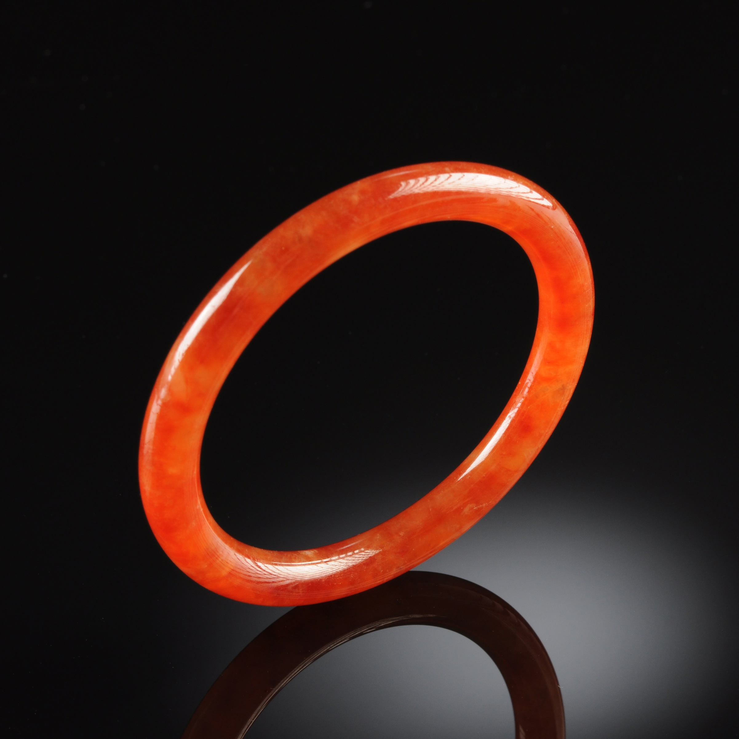 A RARE CHINESE CARVED RED JADEITE BANGLE BRACELET, of circular form. Diameter: 2 3/4"