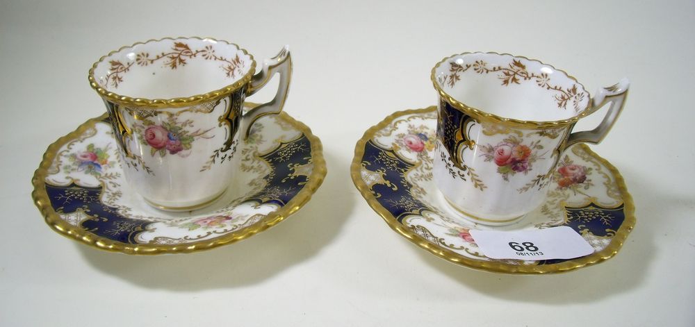 A Coalport coffee set of twelve cups and saucers painted flowers with blue and gilt reserves No AD