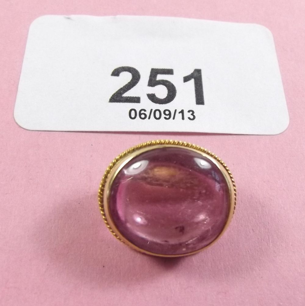 A yellow metal small oval brooch set pink stone
