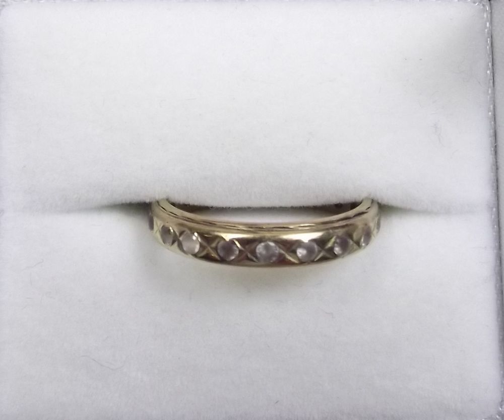 A yellow metal eternity ring set white stones