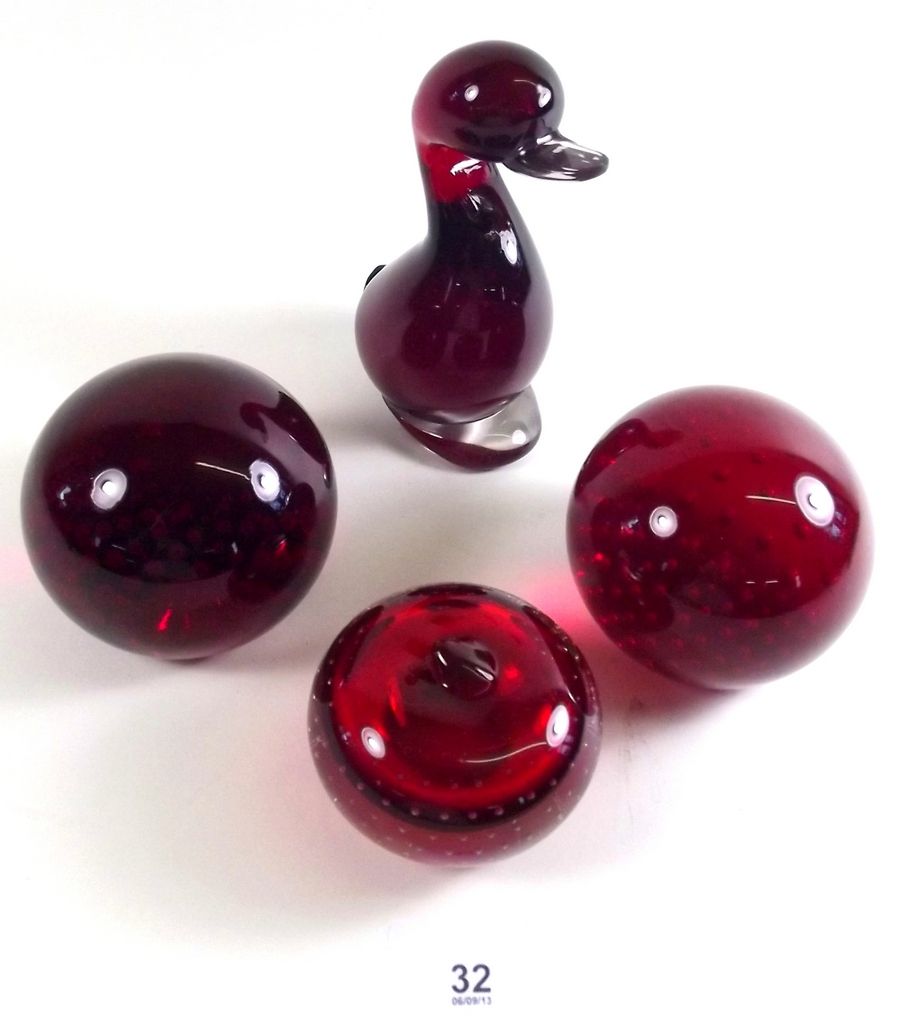 A collection of four Whitefriars ruby glass paperweights including duck