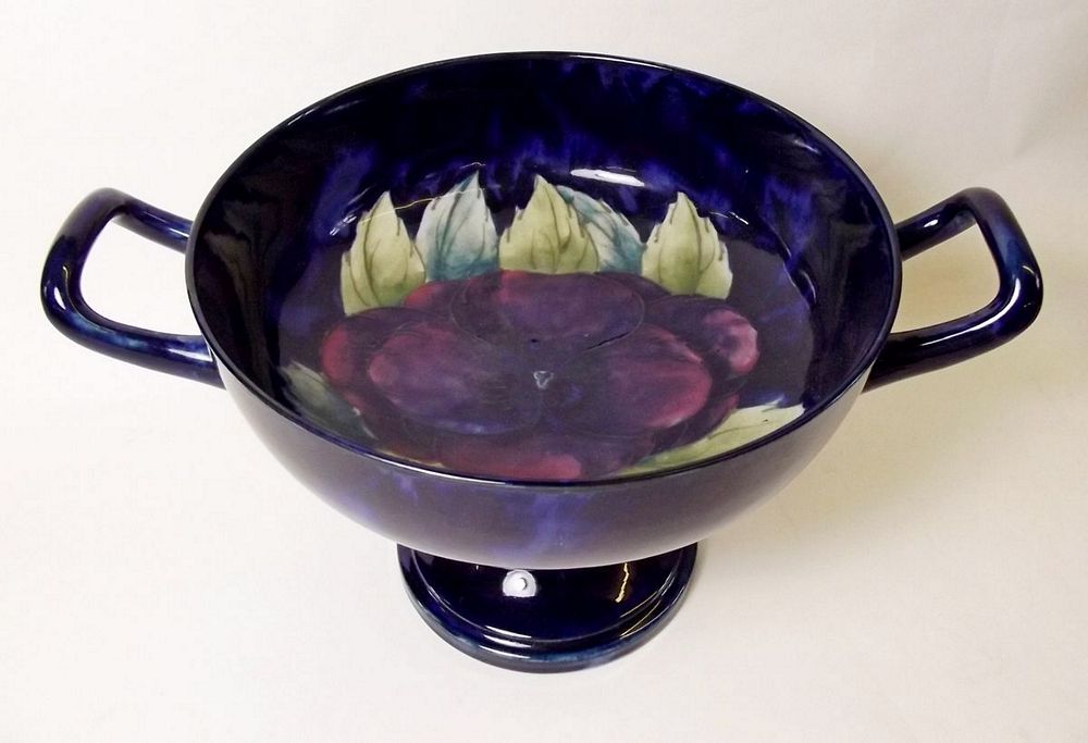 A William Moorcroft tazza painted pansy pattern on a blue ground