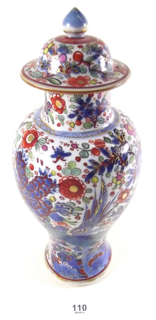 An early 19th century Chinese baluster form blue and white vase and lid with later clobbered bird