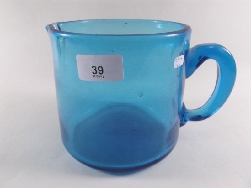An antique heavy blue glass jug 14cm high x 14cm diameter