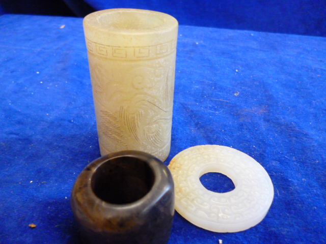 A hardstone archer`s ring, a carved cylinder and a disc (3)