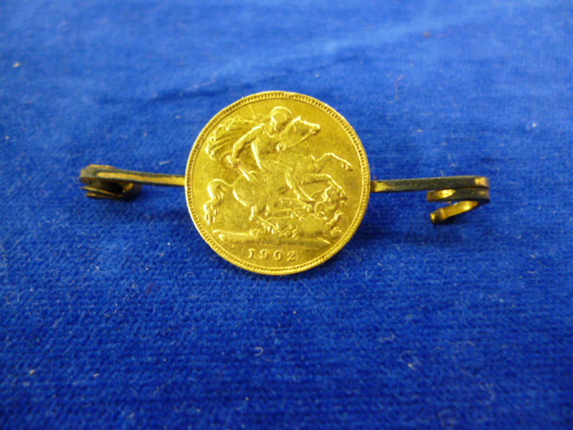 An Edward VI half sovereign dated 1902 mounted on a brooch pin