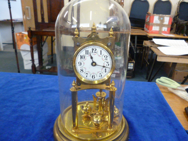 A brass mantle clock under glass dome, porcelain face with floral design (1)