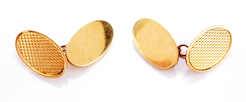 A pair of modern 9ct gold cufflinks, with one engine turned engraved oval panel and one plain oval