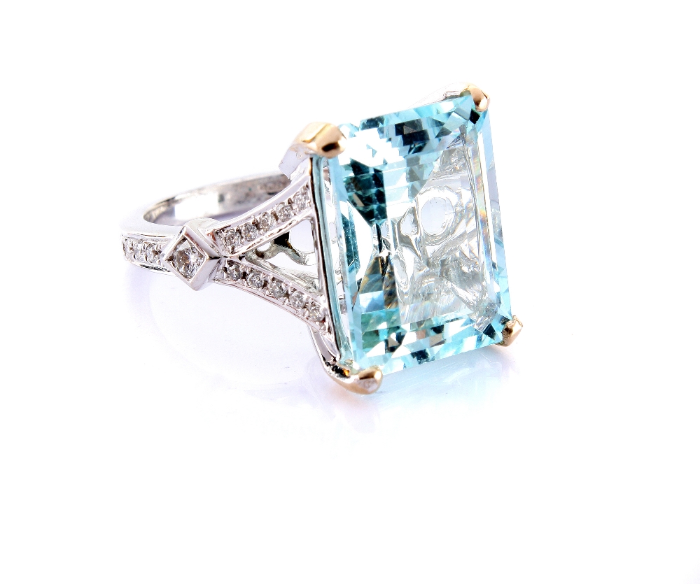 A modern aquamarine and diamond dress ring, the large rectangular cut blue stone set in 18ct white