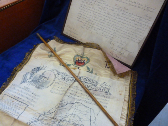 A group of militaria including a framed commission ,swagger stick, Boer War era handkerchief and a