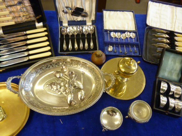 A boxed set of plated napkin rings together with a pair of plated salts, serving dish brass