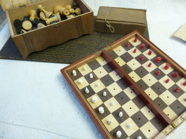 A mahogany cased travel chess set with red and white pieces, together with a quantity of chess