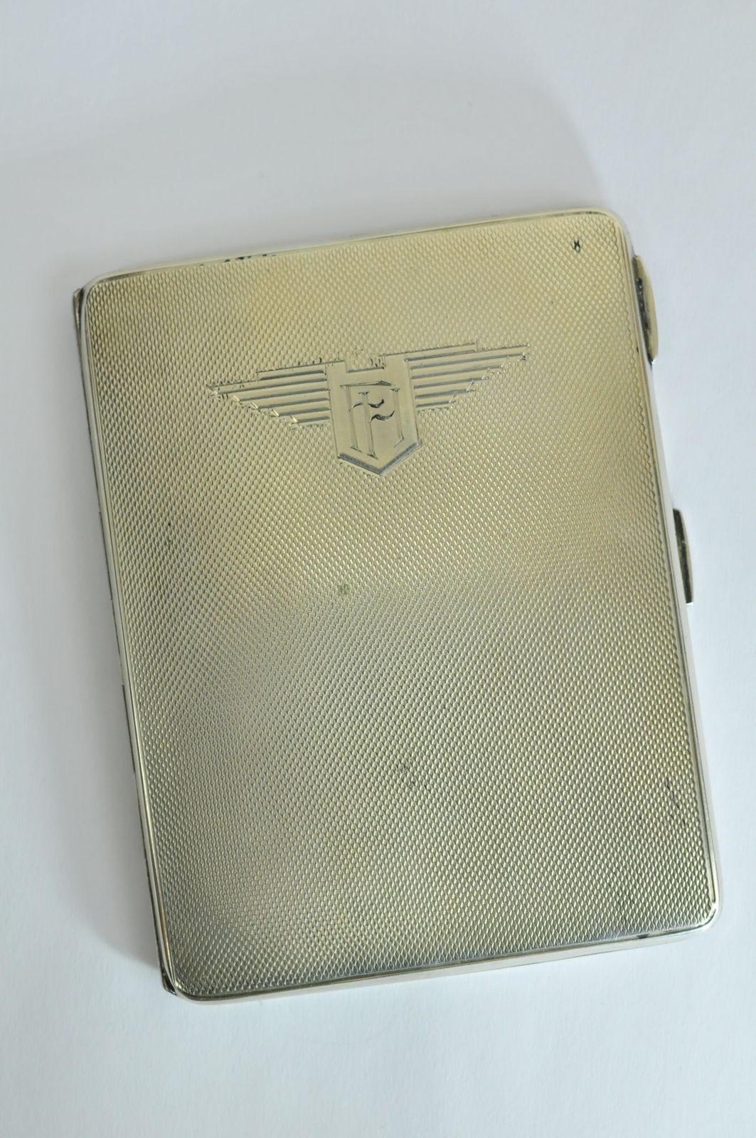 A silver cigarette case having gilt interior