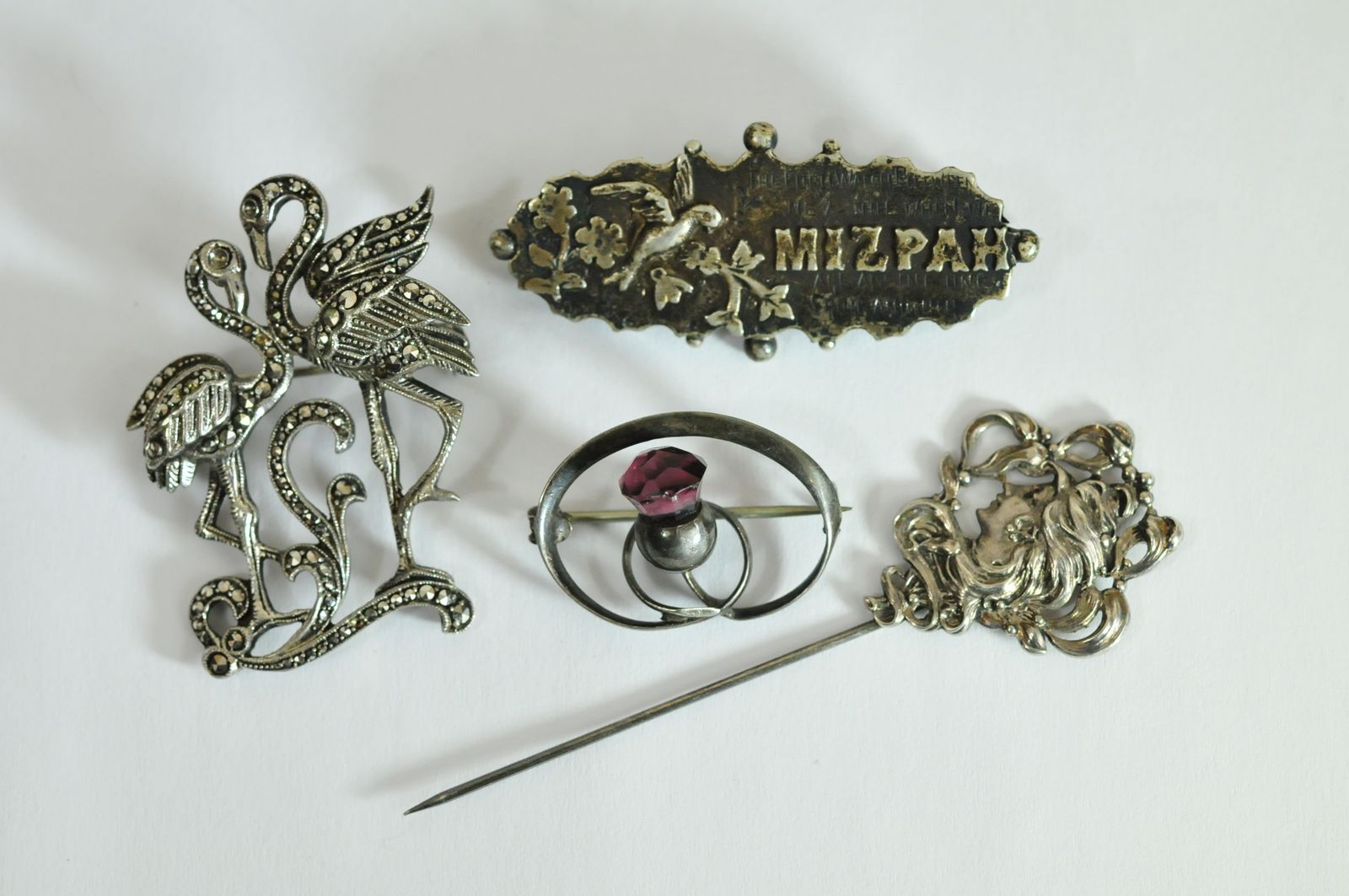 A small collection of silver jewellery oddments comprising a stick pin of Art Nouveau design, a