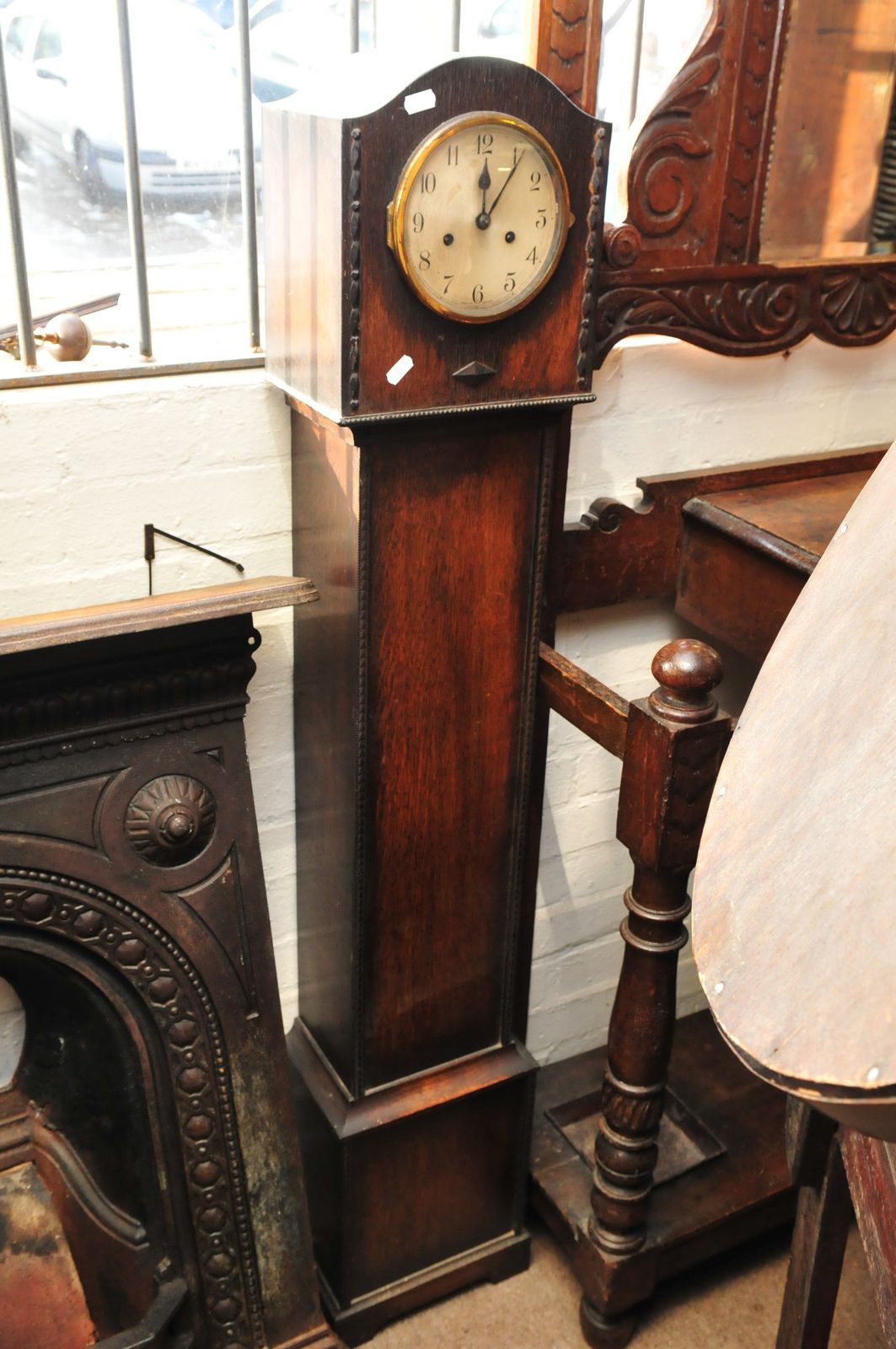 An Oak grandmother clock , the silver dual with Arabic numerals