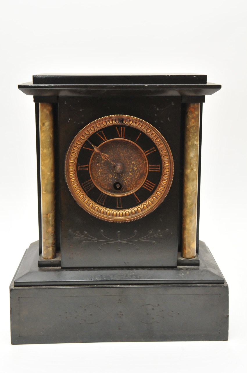 A black slate mantle clock of classical style having engraved pattern to front and metal dial.