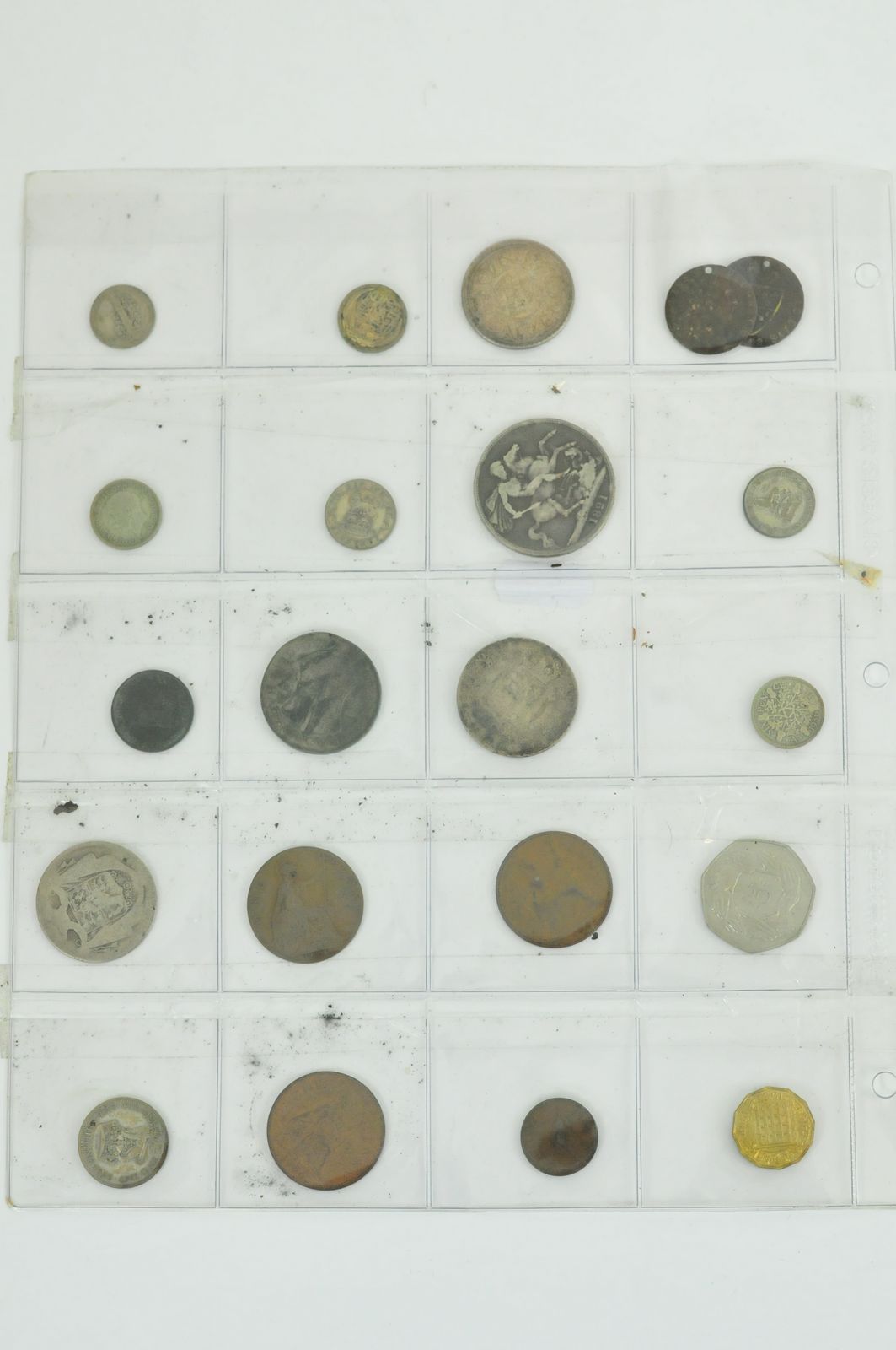 A plastic sheet of various coins including George IIII silver crown, 1918 one rupee coin, and