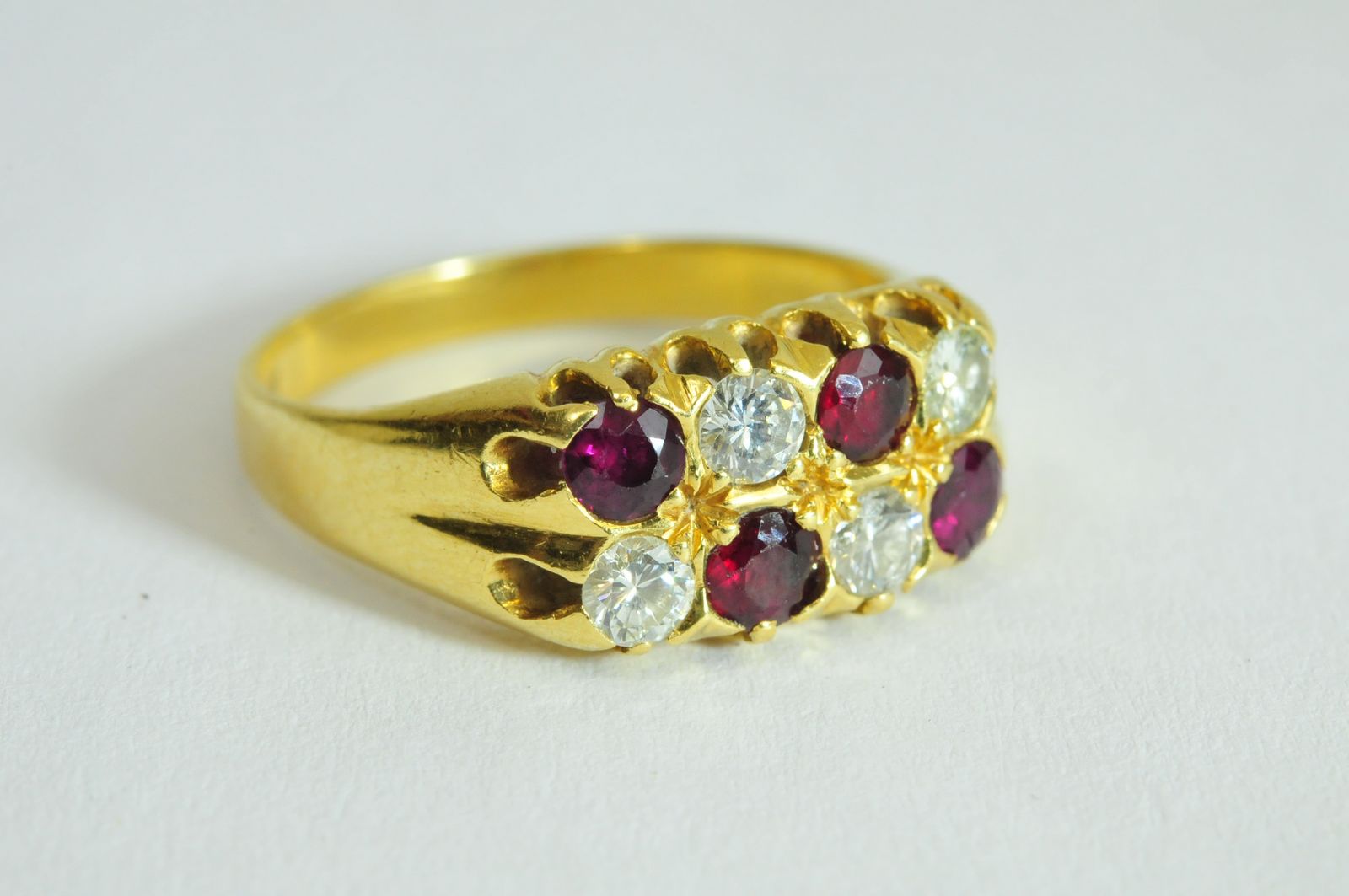 A ladies 18ct yellow gold ring set with two rows of alternating diamonds and rubies