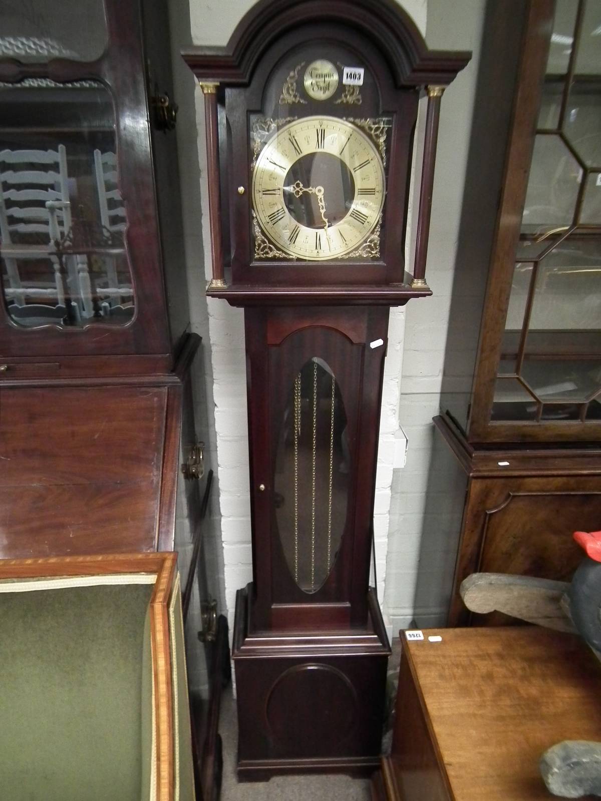 A reproduction mahogany long cased clock with brass chapter ring and glazed door