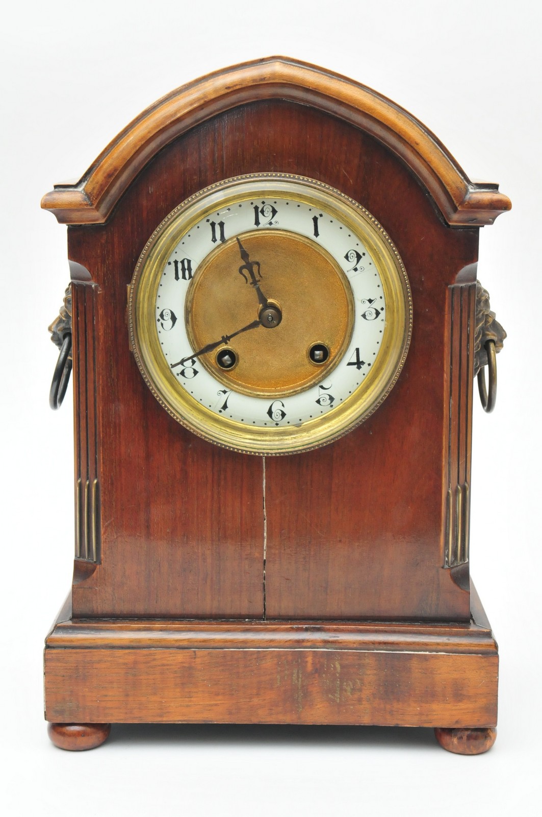 An Edwardian Mantle clock having arched top and enamelled chapter ring , chiming on the hour