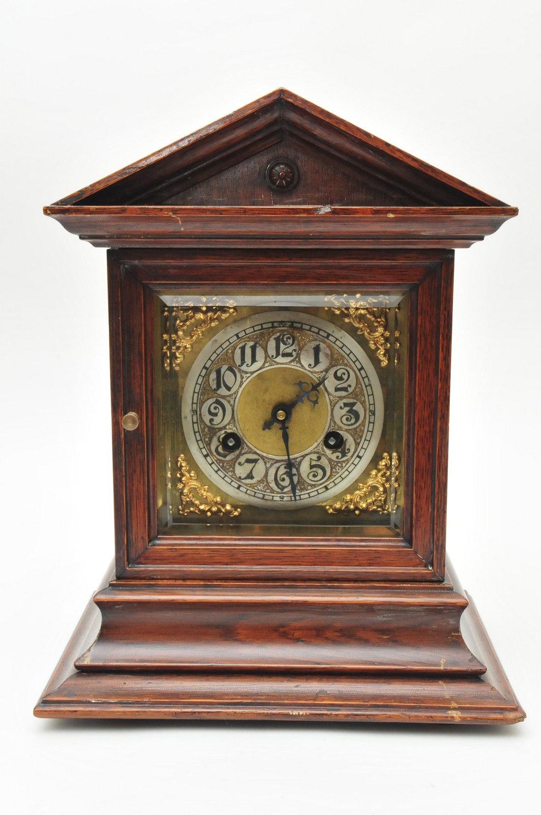 An Edwardian oak cased mantle clock having silvered dial and chiming