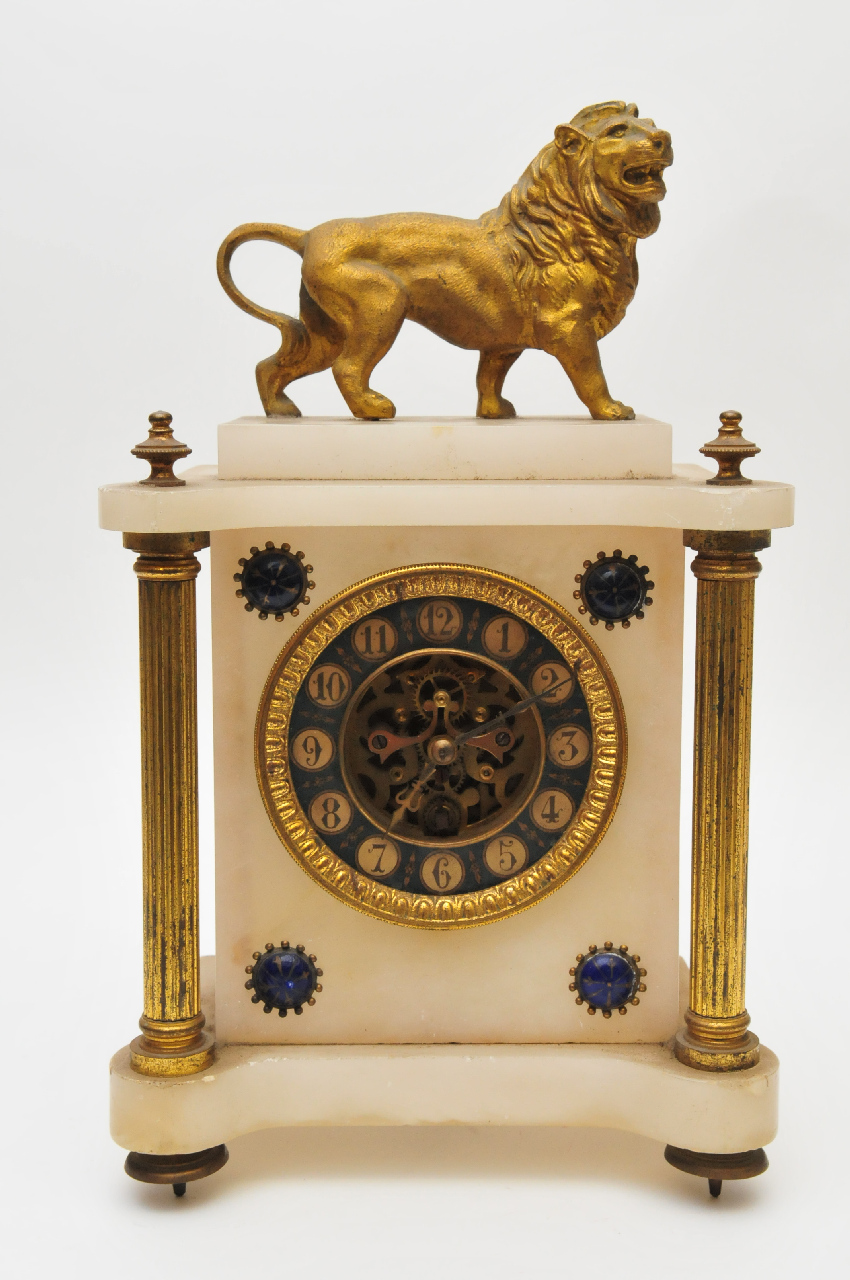 A French white onyx and gilt metal clock, surmounted by a gilt metal lion, the circular dial flanked