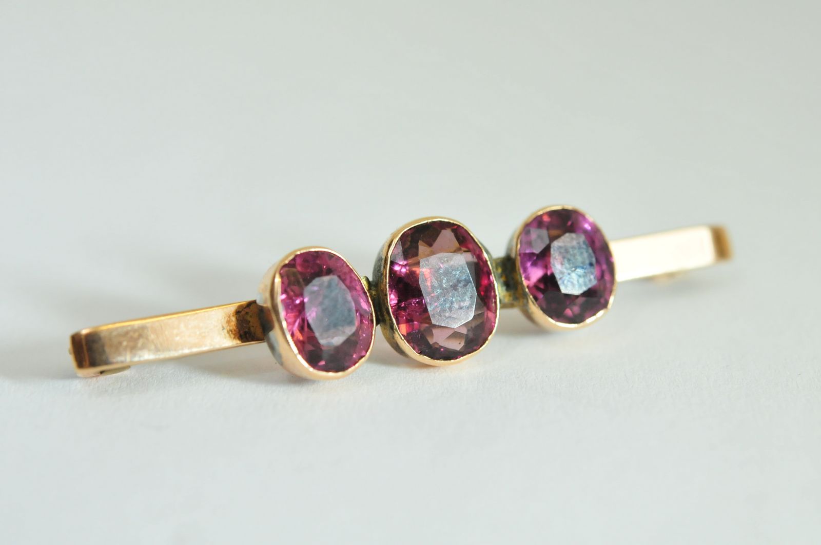 A 9ct gold bar brooch bezel set with three oval cut amethyst