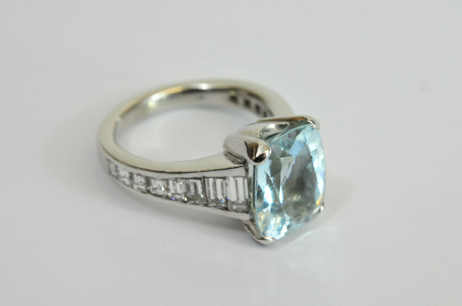 A fine quality ladies platinum ring set with a large central Aquamarine, the shoulders channel set