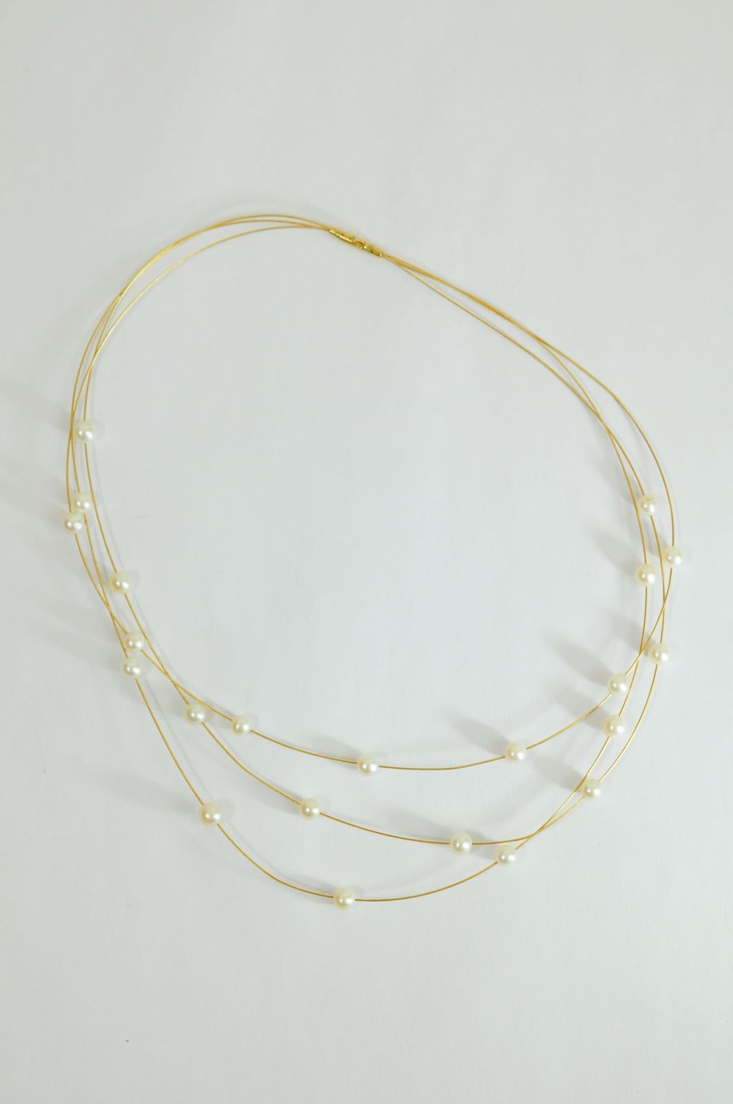 A ladies 18ct yellow gold three row wire necklace mounted with spaced pearls