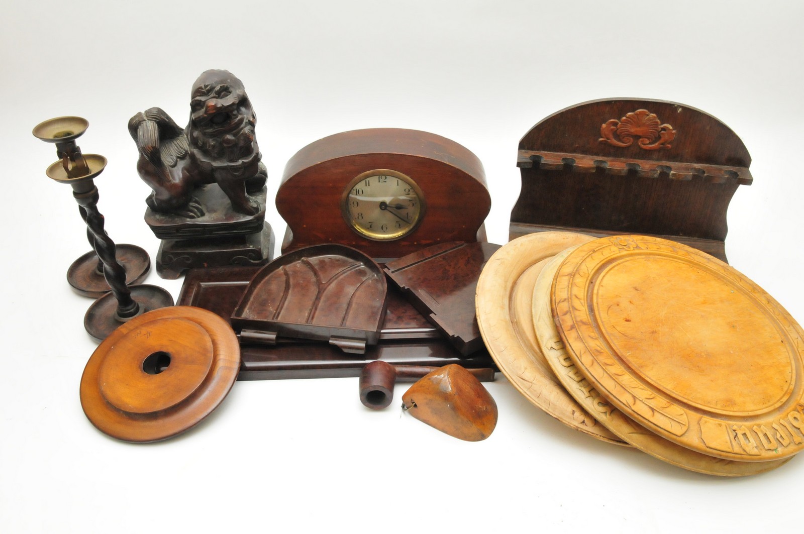 A box of mixed items including a clock, wooden model of an oriental temple lion, and a bakelite