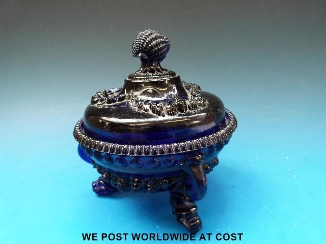 A moulded 19thC blue glass lidded pot with dolphin feet