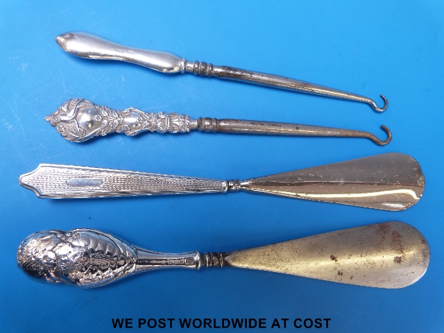 Two hallmarked silver handled shoe horns and two hallmarked silver button hooks