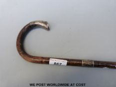 A Victorian walking cane with silver collar and tip with an interesting flared design and chasing