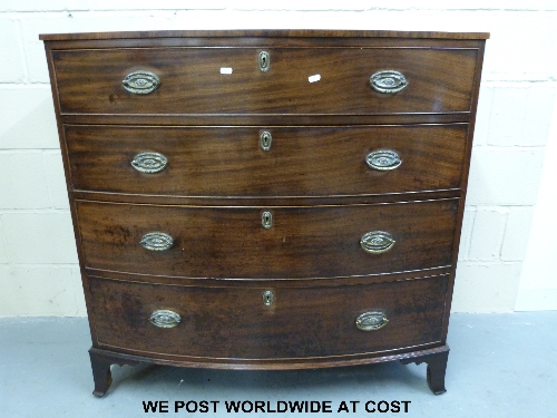 A Georgian bow fronted mahogany chest of four graduated drawers with oval drop handles, the top with