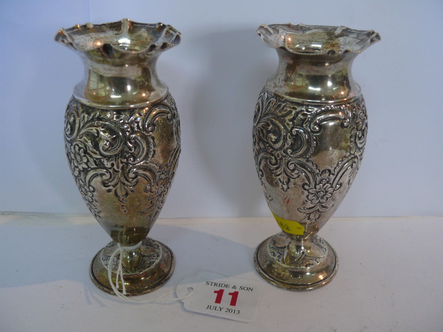 A pair of Victorian silver baluster vases, having floral and C scroll decoration, crimped rims,