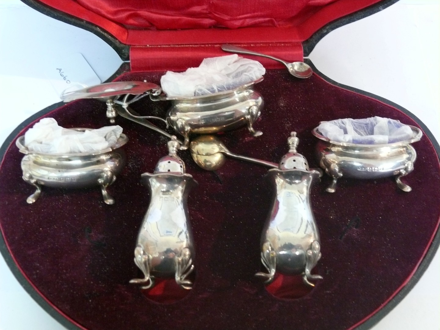 A silver five piece condiment set comprising: two pepperpots, two salts and one mustard, maker E S