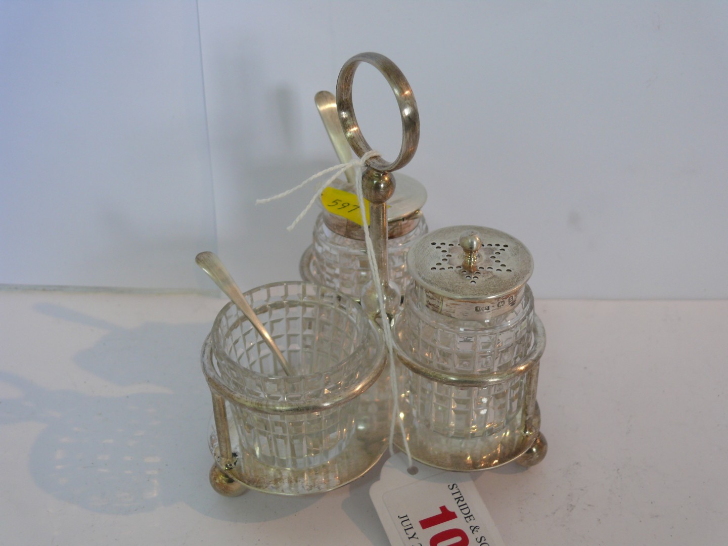 A three leaf clover shaped silver condiment stand, having cut glass containers with silver lid to