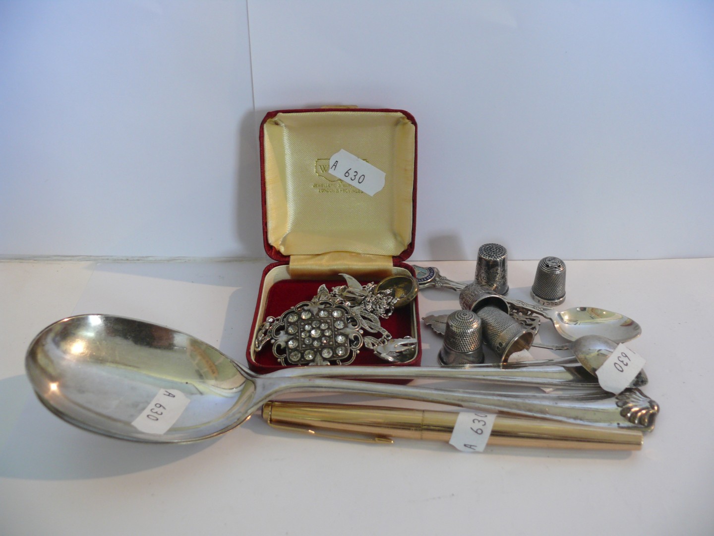 Four various silver thimbles, two silver and enamel commemorative spoons, a gold plated Parker