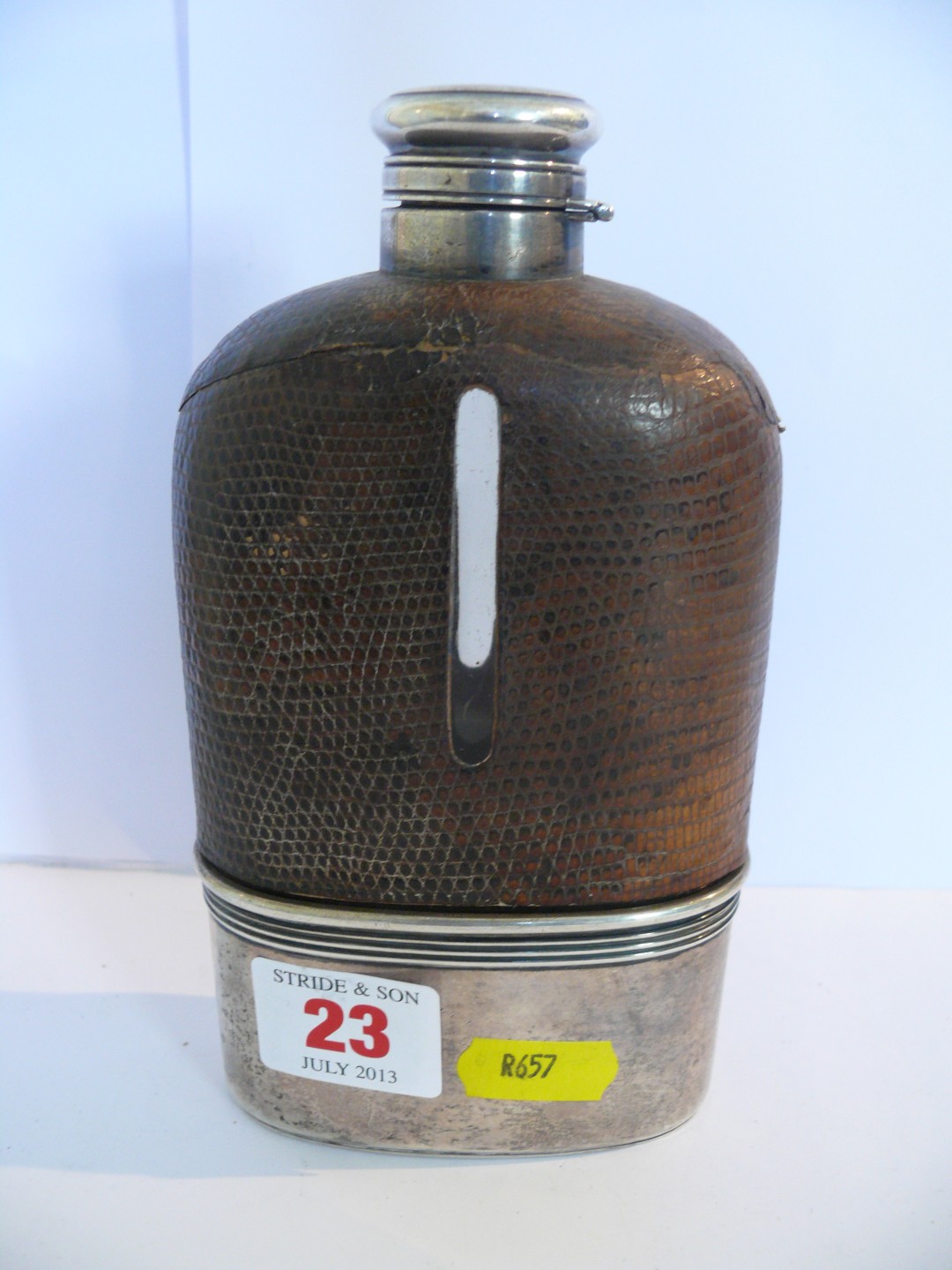 An oversized sterling silver mounted glass hip flask, with reptile skin cover, engraved initials,