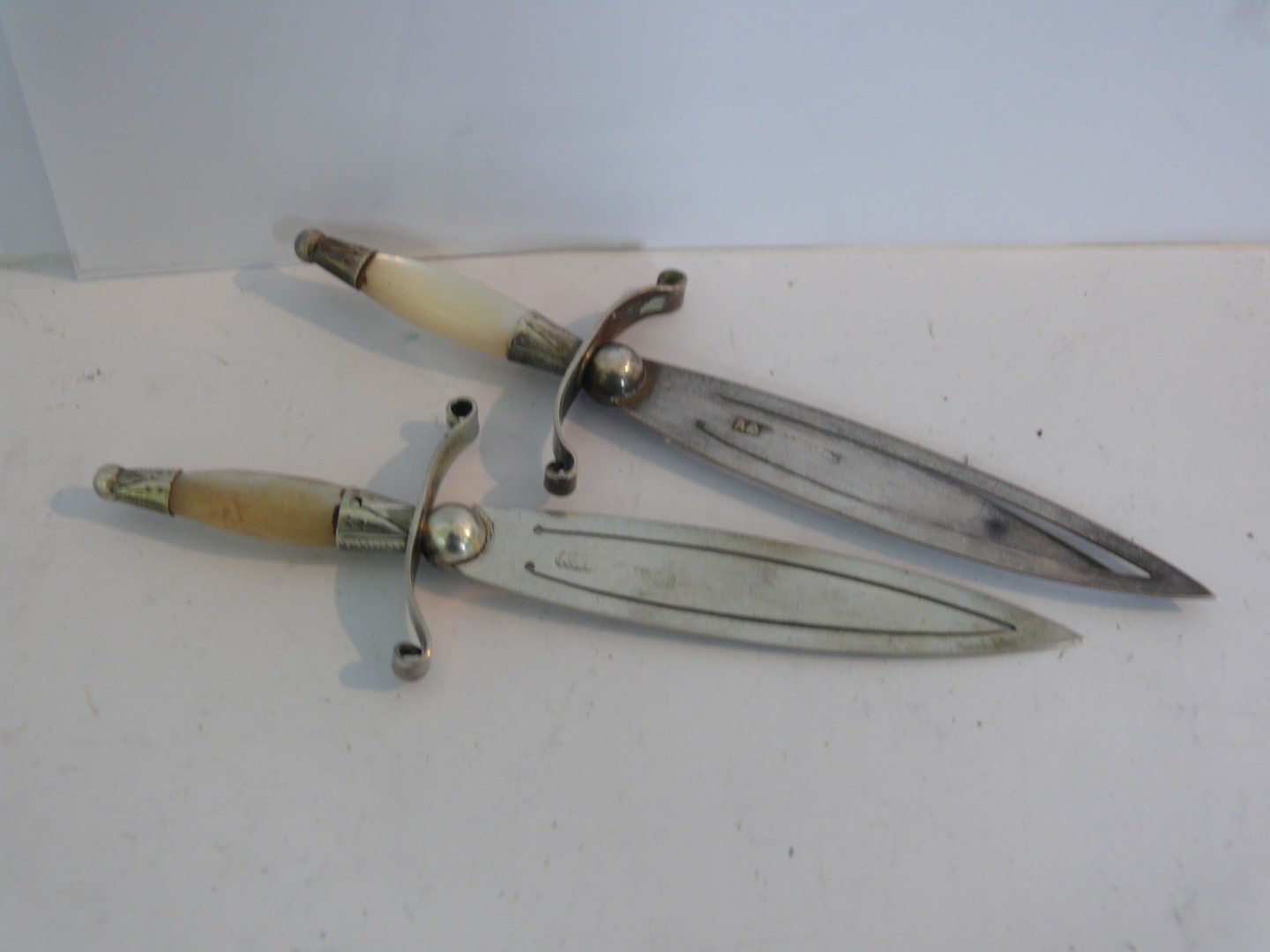 A pair of late Victorian silver dagger shaped page markers, having mother of pearl handles by Adie &