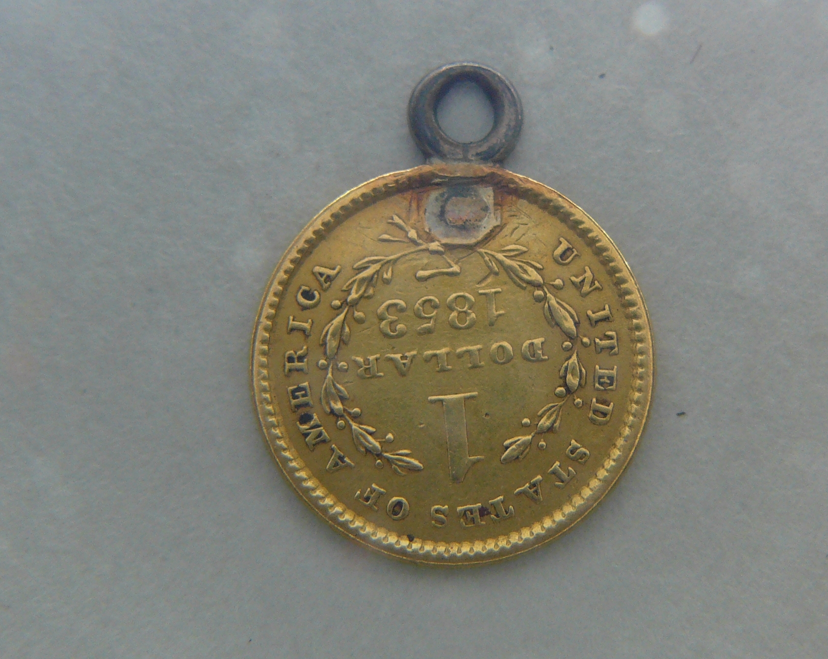 A USA gold $1 coin 1853, with attached suspension ring.