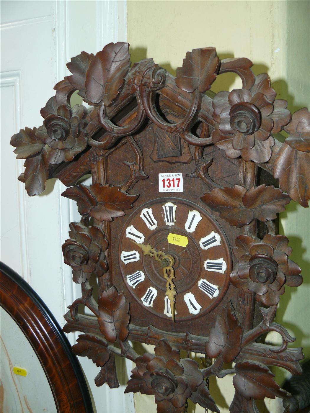 A late 19th/early 20th century Black Forest carved wood cuckoo clock, with carved and pierced leaf